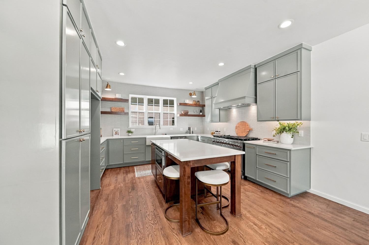 Sage green kitchen with island and bar stools