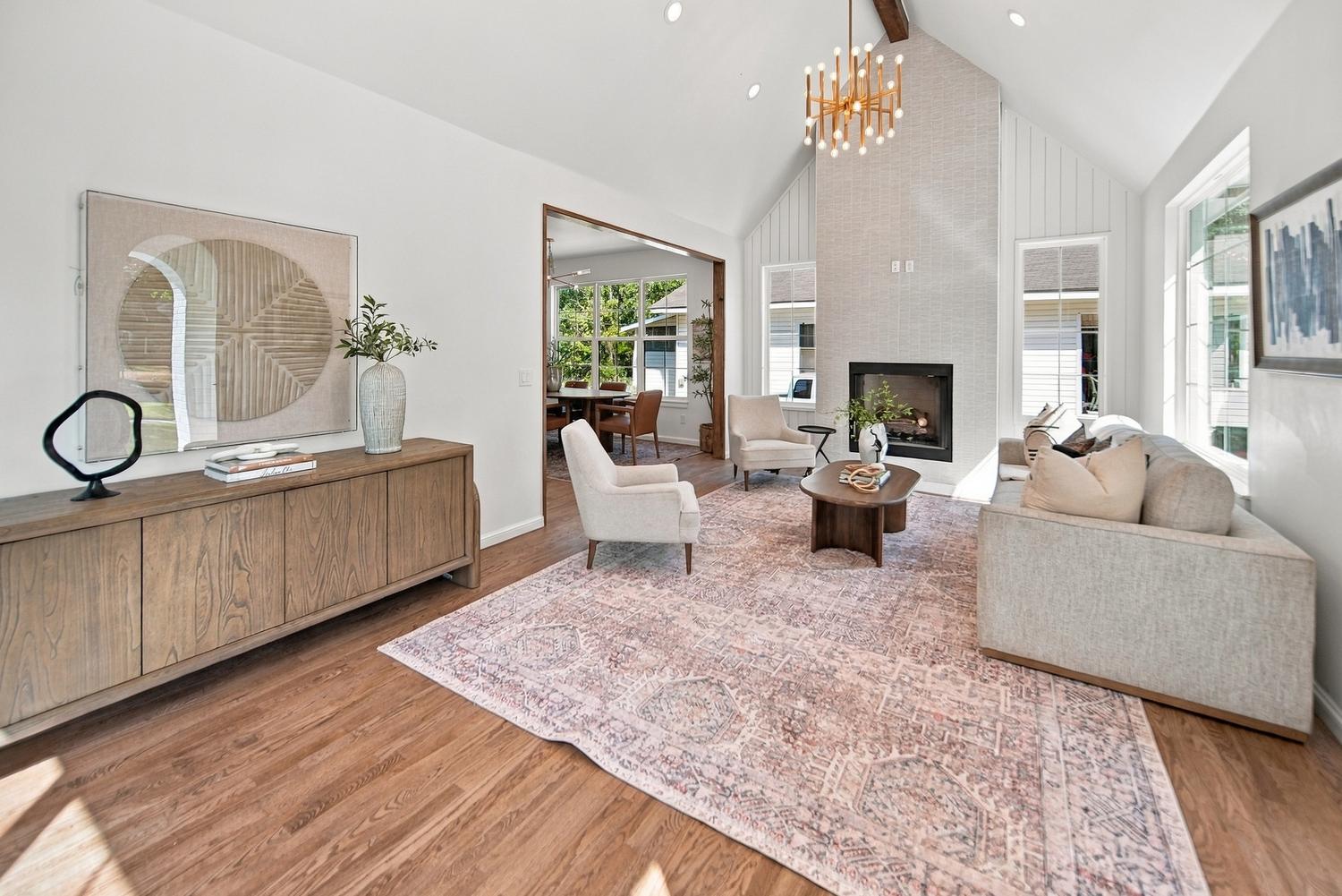 Vaulted living room with fireplace and brass chandelier at 818 S Pickard